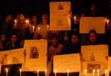People participating in a candle light protest on the banks of Dal Lake in Srinagar -- Photo: Bilal Bahadur