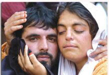 A woman cries as she hugs her brother after his surrender in Rampur
