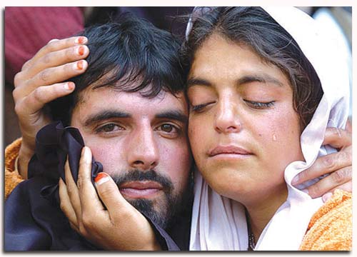 A woman cries as she hugs her brother after his surrender in Rampur