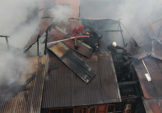 Fire fighters dousing the flames on the roof  of residential  house in Srinagar.