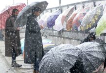 After long dry spell Kashmir finally witnesses snowfall. Two boys checking umbrellas at Amira Kadal in Srinagar during fresh spell of snowfall.