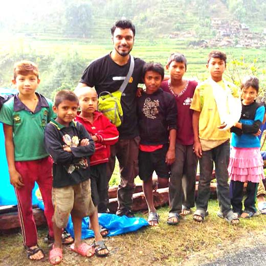 Er Abdul Wajid  standing with children of quake hit Nepal.