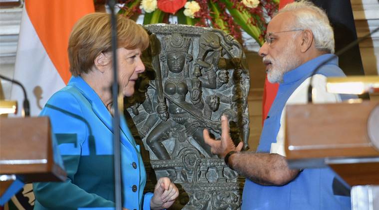 Prime Minister Narendra Modi and German Chancellor Angela Merkel with a 10th centery idol of Hindu goddess Durga, that was returned by Germany, at Hyderabad House in New Delhi on Monday.