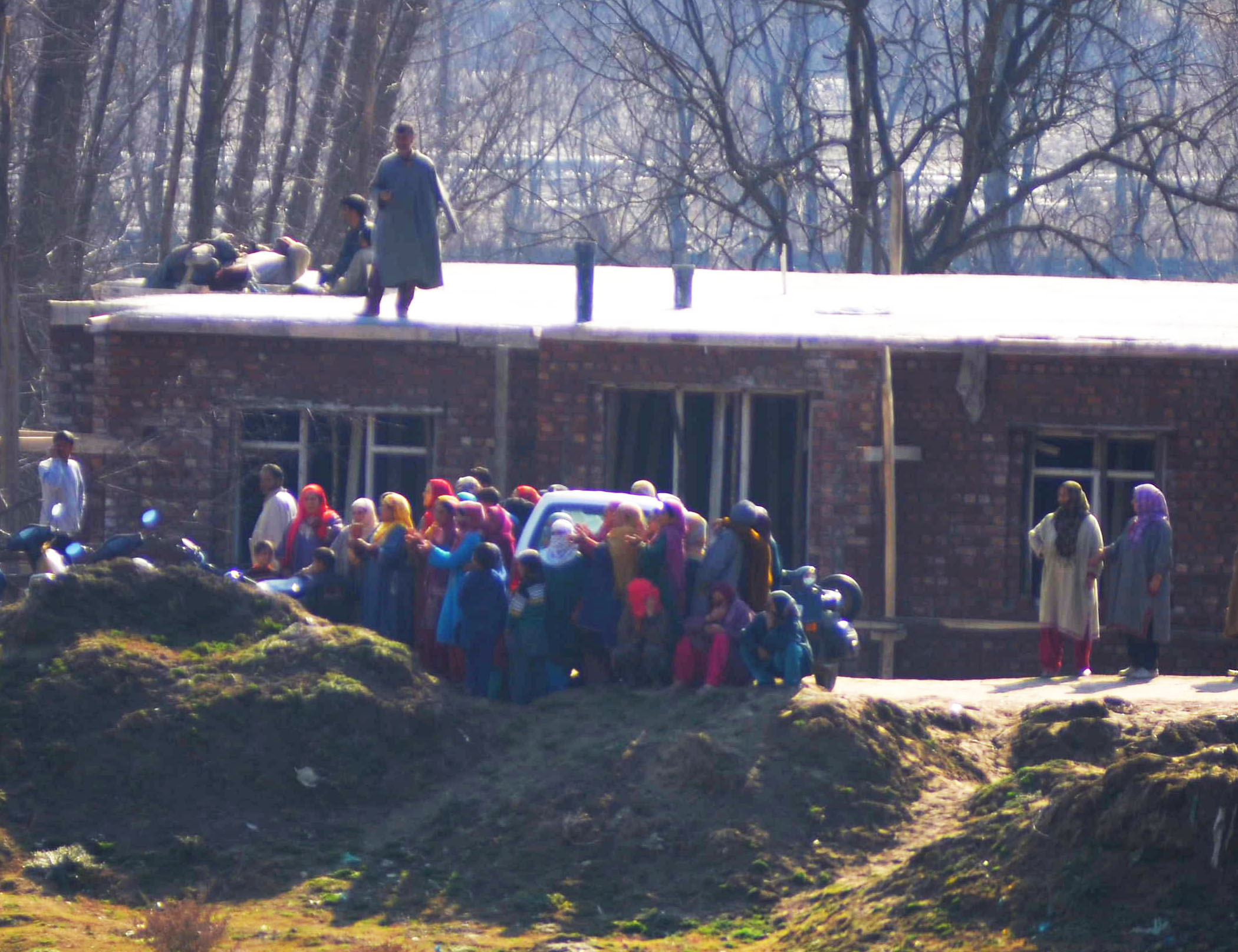 Women on the riverbank singing peans for the trapped militants. (Photo: Bilal Bahadur/KL)