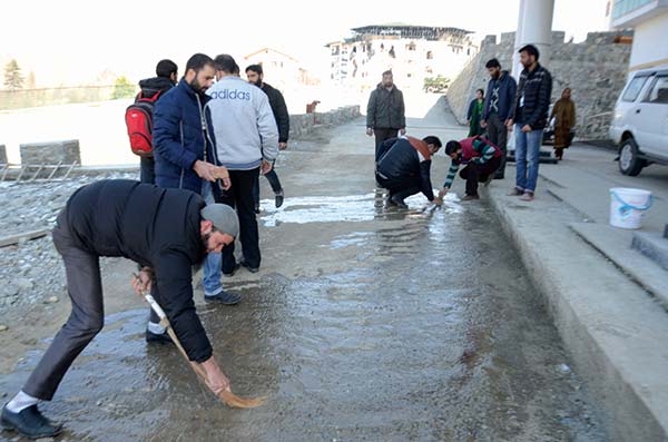 J&K EDI employees washing off blood stains a day after encounter ended.