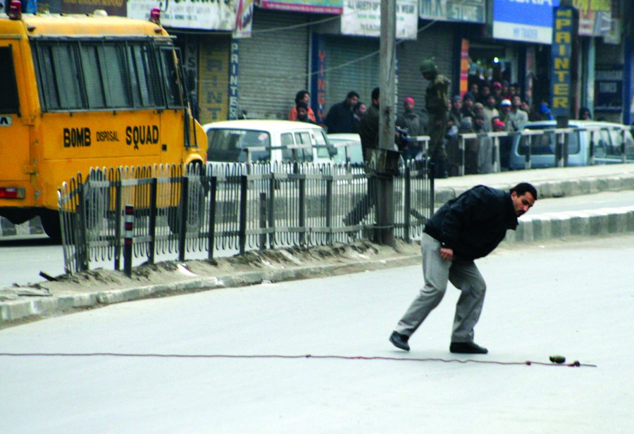 An expert of the bomb disposal squad prepares to defuse a grenade that was hurled towards a patrol of paramilitary and policemen, but failed to go off in Srinagar, on 22 January 2010. Security has been stepped up in Kashmir and other parts of India ahead of Republic Day ceremonies which falls on 26 January 2010, marking the day in 1950 when the country adopted its republican constitution photo by bilal bahadur