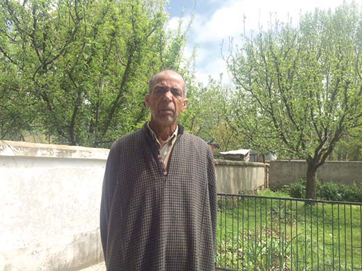 Ghulam Hassan Sheikh in front of his orchard inside the Blue gate.