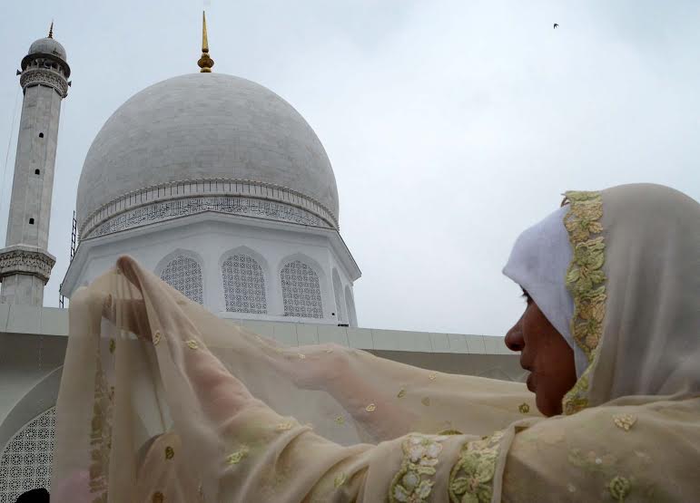 Kashmiri Muslim women raise their hands as they pray upon seeing a relic believed to be hair from the beard of Prophet Mohammed during Meeraj-un-Nabi celebrations at the Hazratbal shrine in Srinagar May 5, 2016. PHOTO BY BILAL BAHADUR