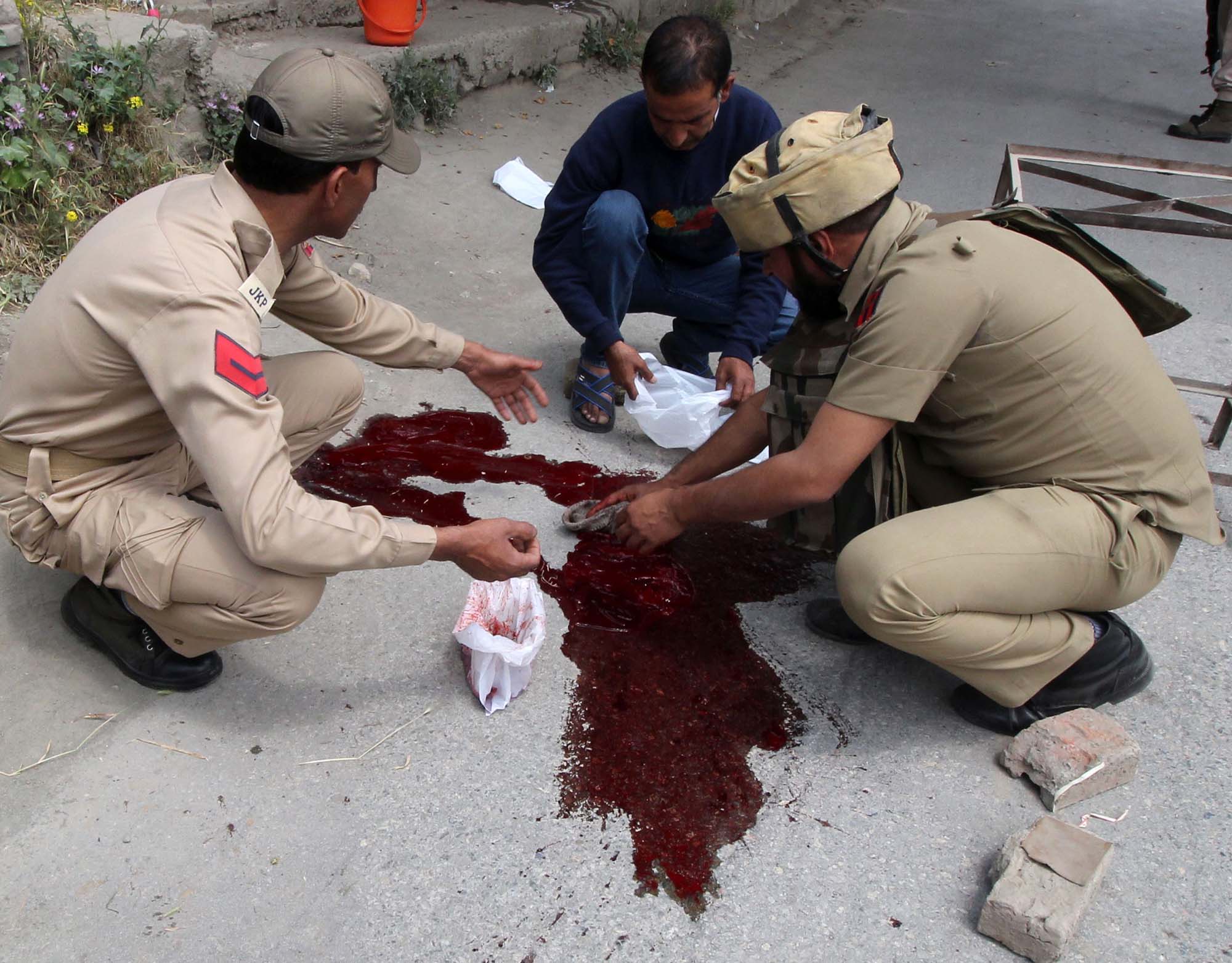 policemen wash the blood of their colleagues in Zadibal area of Srinagar on May 23, 2016. Two policemen were shot dead by suspected militants early morning in Srinagar. PHOTO BY BILAL BAHADUR