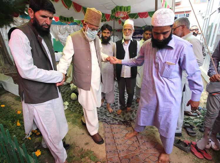 Ailing Syed Ali Geelani being escorted by his associates to walk into the seminar at his Hyderpora residence on Sunday. (KL Image: Bilal Bahadur)