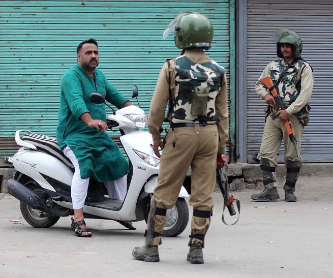 A Scooty rider being stopped by CRPF man inSrinagar as curfew continued in Kashmir on 8th consecutive day. (KL Image: Bilal Bahadur)