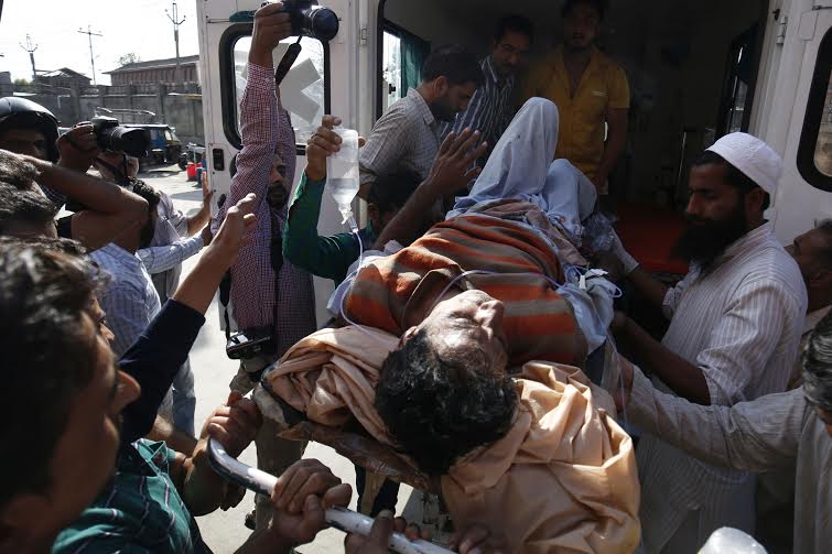 People carry an injured on a stretcher to shift him to a local hospital in Srinagar, 10 July 2016. Clashes continued in Kashmir for the third day against the killing of top militant commander Burhan Muzaffar Wani on late 08 July.PHOTO BY BILAL BAHADUR