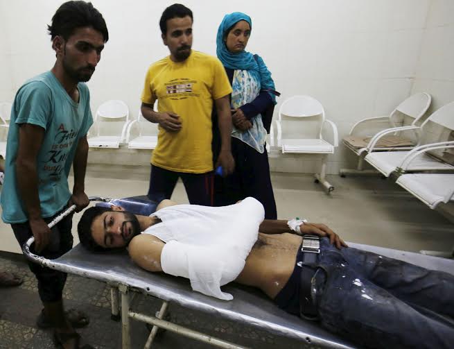 People carry an injured on a stretcher to shift him to a local hospital in Srinagar, 10 July 2016. Clashes continued in Kashmir for the third day against the killing of top militant commander Burhan Muzaffar Wani on late 08 July.PHOTO BY BILAL BAHADUR