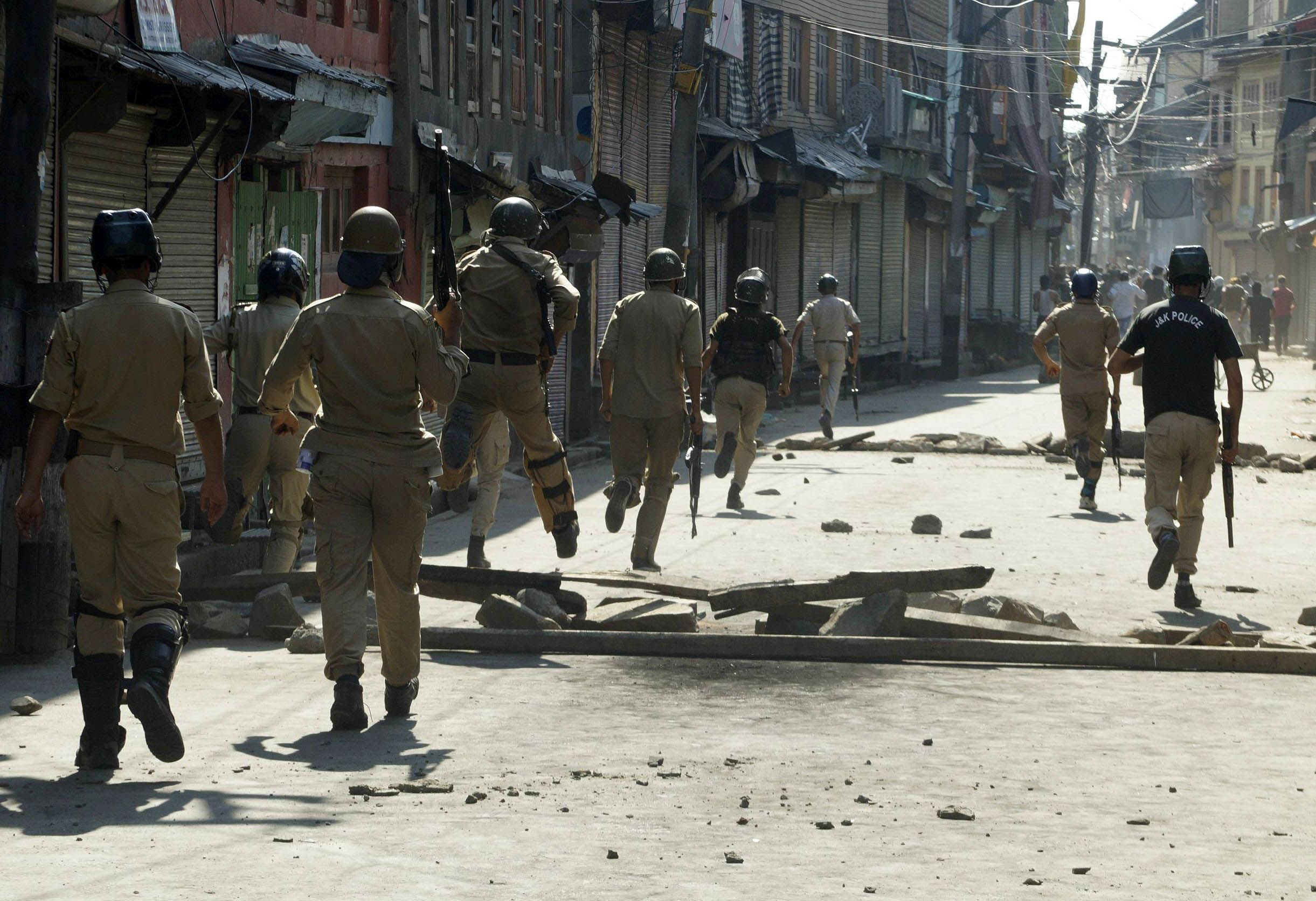 Protesters throw stones at police after clashes erupted in old city following killing of a civilian by forces near martyrs graveyard, during his funeral in Srinagar, Wednesday, Aug. 3, 2016. PHOTO BY BILAL BAHADUR