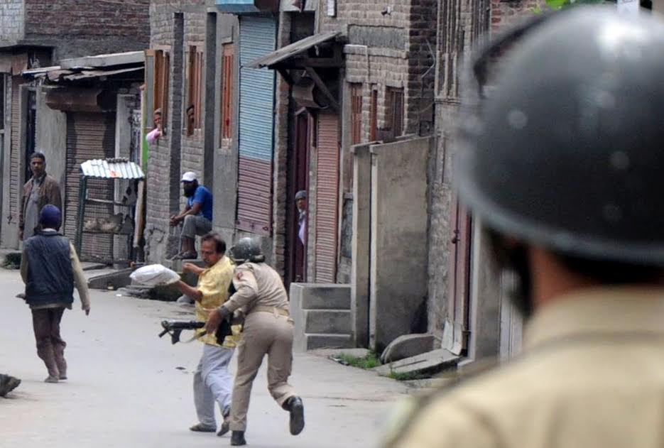 A civilian being beaten up by forces in Batamaloo area of Srinagar on August 30, 2016. (KL Image: Bilal Bahadur)