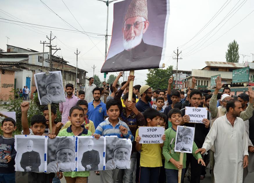 Kashmiri youths hold images of Syed Ali Geelani during a protest in Srinagar on August 27, 2016. (Photo: Bilal Bahadur/KL)