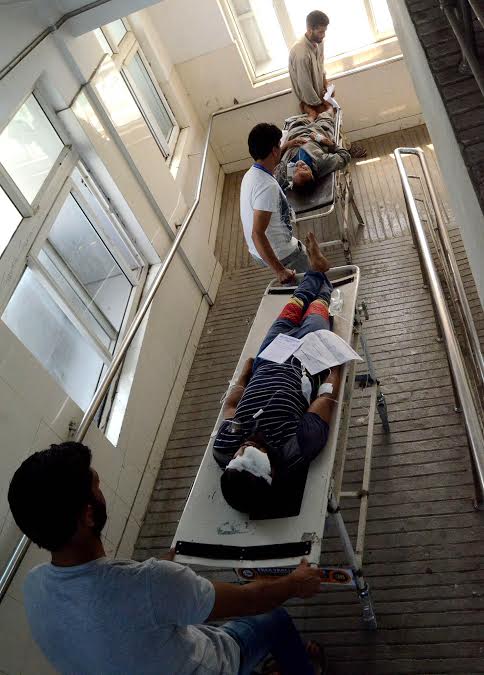 Volunteers shift a pellet hit injured to a ward in SMHS Hospital on August 24, 2016.