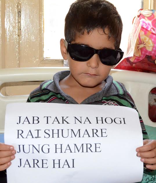 A four year old child hit by pellets holding placard in SMHS Hospital Srinagar. (KL Image: Bilal Bahadur)