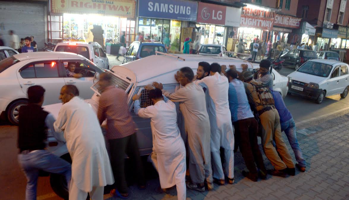 Insaaniyat: As business establishments opened in Lal Chowk following Hurriyat Conference call at 6 PM on Sep 08, 2016, a CRPF vehicle got stuck in a road side drain. When the men in uniform failed to push it out, the passerby came and did it. (KL Image courtesy: Mehraj Byat)