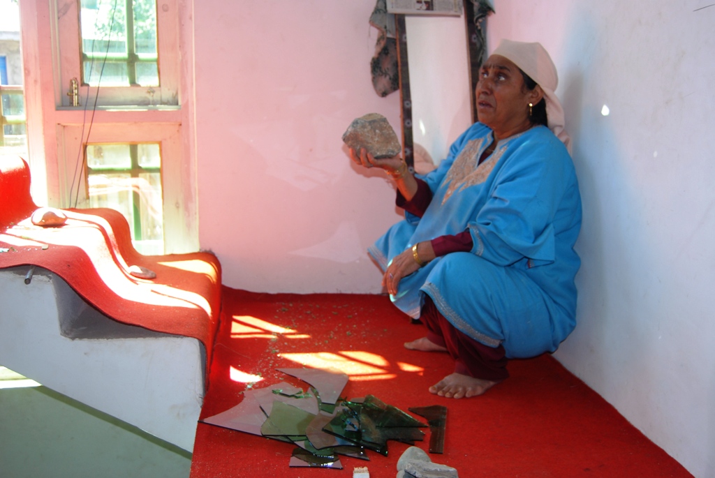 An elderly lady, shows the damages done by forces in Fatehpur area of Islamabad district. KL IMAGE SHAH HILAL