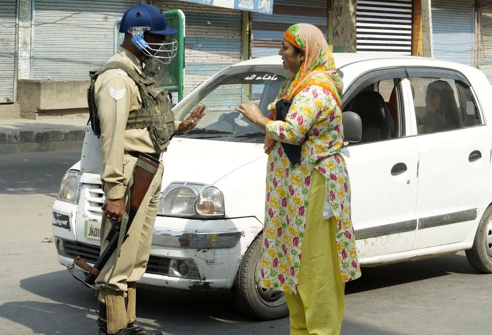 A government official seeking permission from a CRPF man in Old Srinagar to pass through a check point, on Sep 30, 2016. (KL Image: Bilal Bahadur)