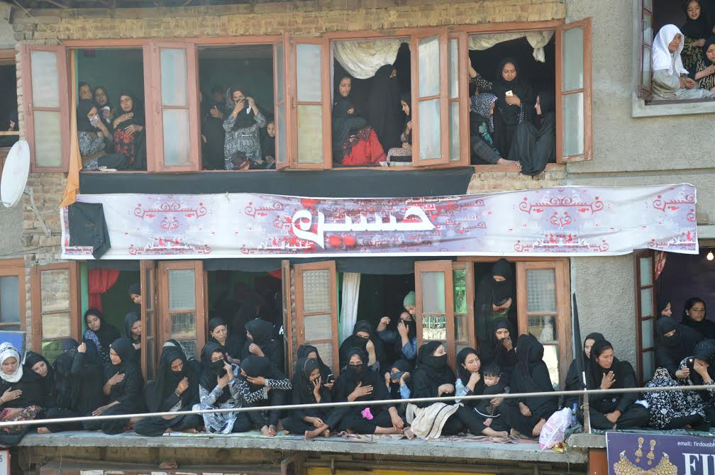Mourning women look out of their homes while an 'Ashoora' procession (not in picture) walks past residential houses in Old Srinagar on Oct 12, 2016. (KL Image: Bilal Bahadur)