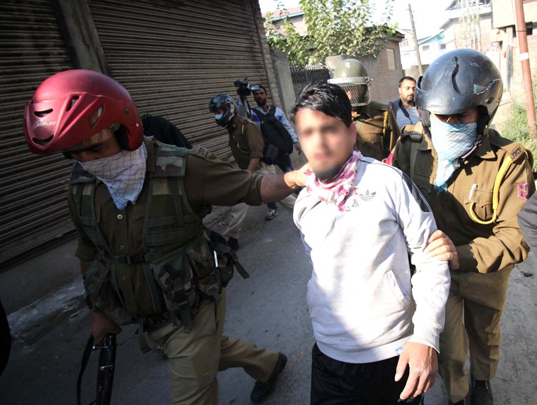 A youth being arrested in Barzulla on Oct 21, 2016 by police men. (KL Image: Bilal Bahadur)