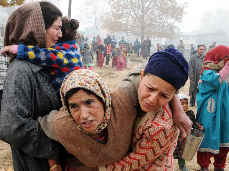 A women stopped by her relatives as she tries to enter her house in Buchwara. Photo: Bilal Bahadur)