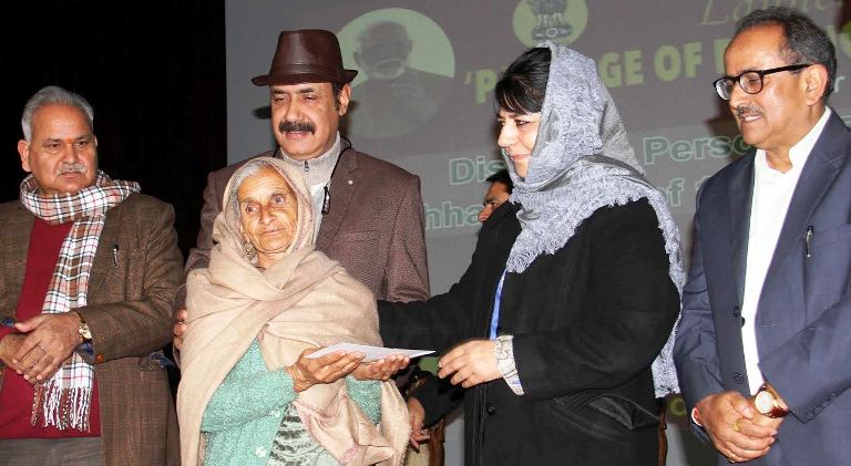 Chief Minister handing over bank cheques to the DPs of PaK in Jammu