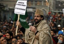 Mirwaiz Umar holding a playcard while addressing protesters outside Jamia Masjid Srinagar. KL Image by Bilal Bhadur
