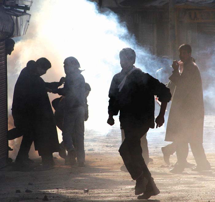 Youngsters run for cover after forces fired a tearsmoke shell in downtown Srinagar. Pic: Bilal Bahadur