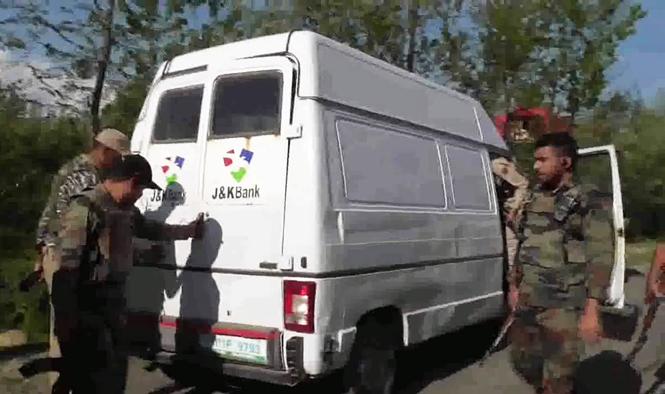 Police and army personnel inspect J&K Bank's cash delivery vehicle after it was attacked by suspected militants in Kulgam's Pombai village on Monday evening. The attack left 5 policemen and 2 bank employees dead.