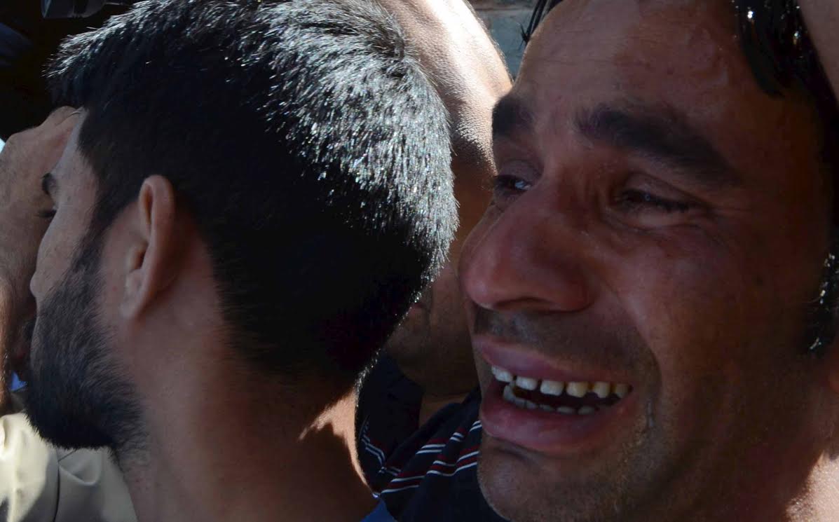 Relatives of slain policeman mourn near his coffin during a wreath laying ceremony in Srinagar on June 16, 2017, PHOTO BY BILAL BAHADUR