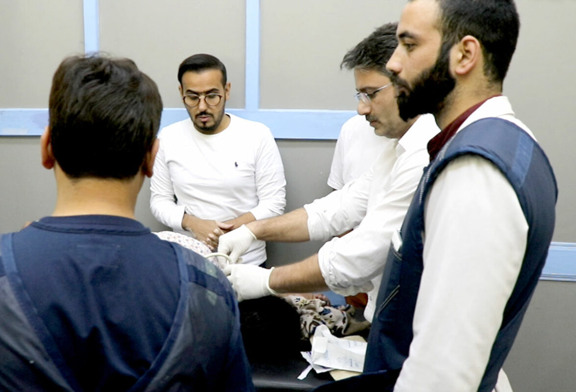 Dr-Tramboo-treating-a-patient-in-his-lab-while-the-foreign-doctors-are-watching-him.