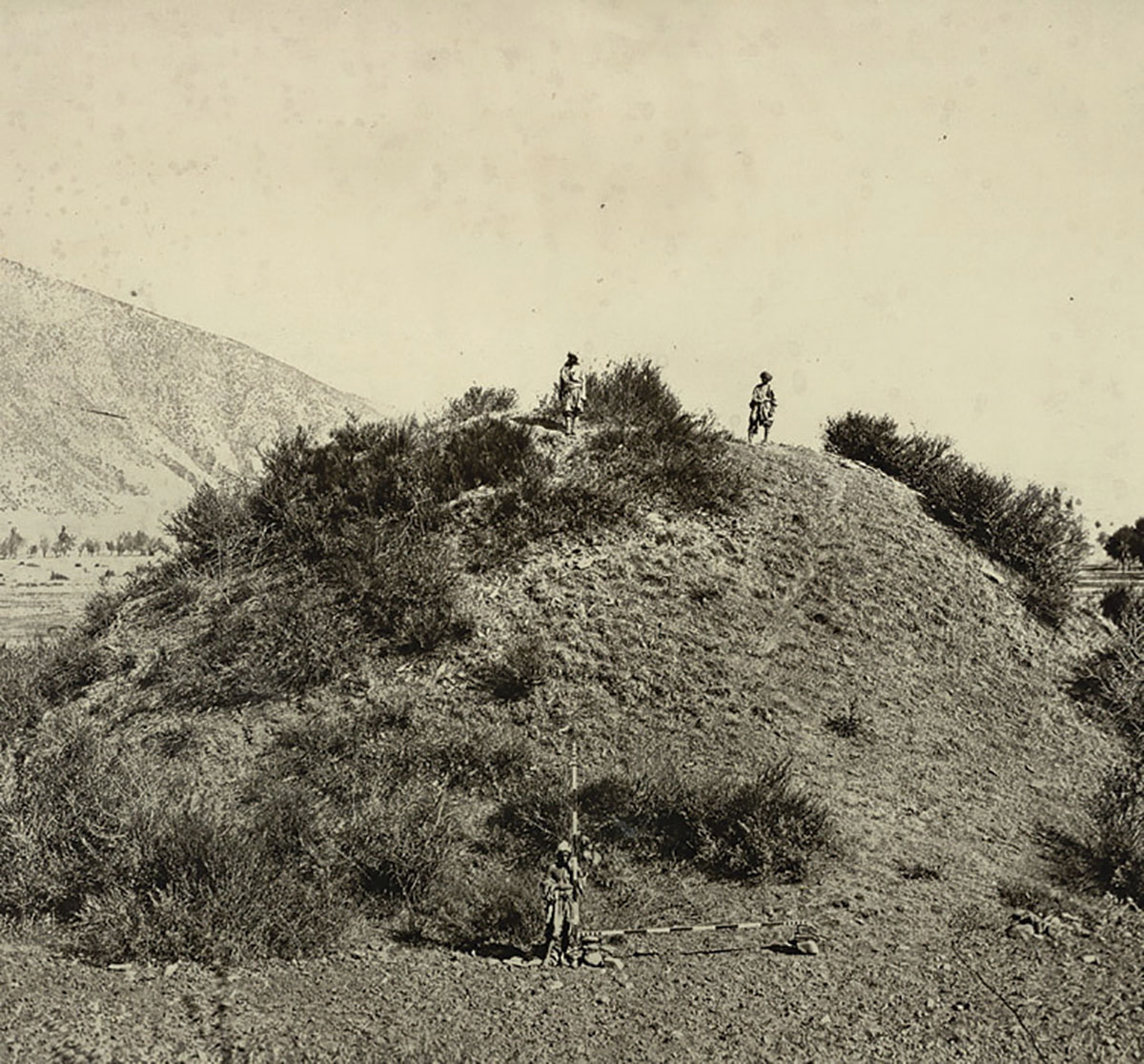 Photograph of a Buddhist stupa mound near Baramulla in Jammu and Kashmir, taken by John Burke in 1868. Buddhism was established in Kashmir from the third century BC but declined by the 8th century AD, eclipsed by Hindu Vaishnavism and Shaivism. Two of the most important sites for Buddhist remains in the Kashmir valley are Harwan near Srinagar and Ushkur near Baramulla.