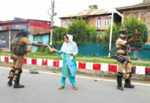 CRPF checking the medical documents of a woman during restrictions in old city of Srinagar. KL Image by Bilal Bahadur