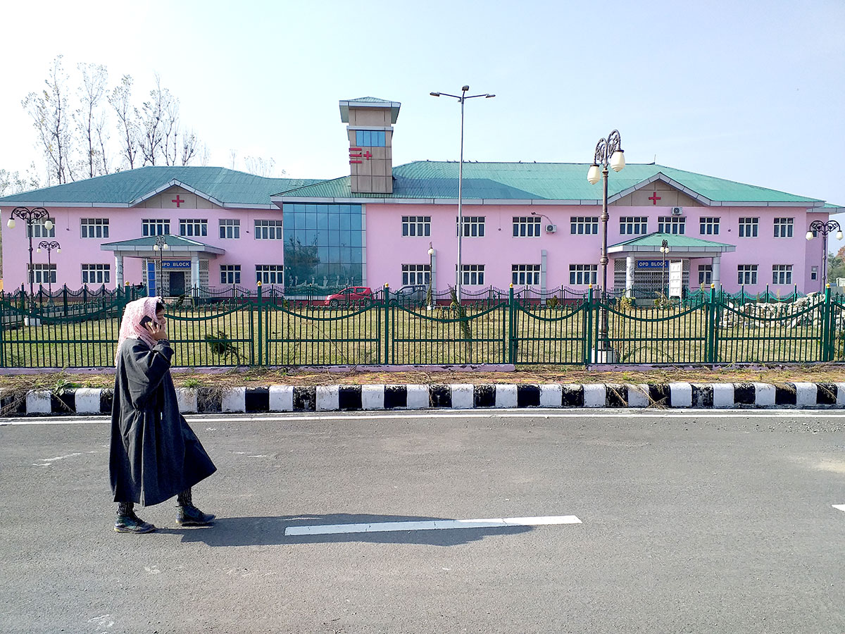 A girl walks outside deserted Dooru hospital building. KL Image by Shah Hilal