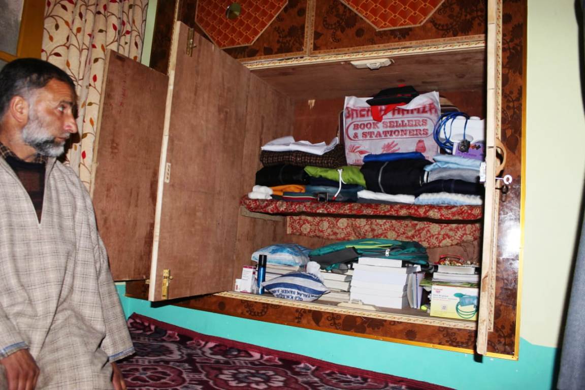 Abdul Rashid bhat, father of Aadil Ahmad looking at his belongings.