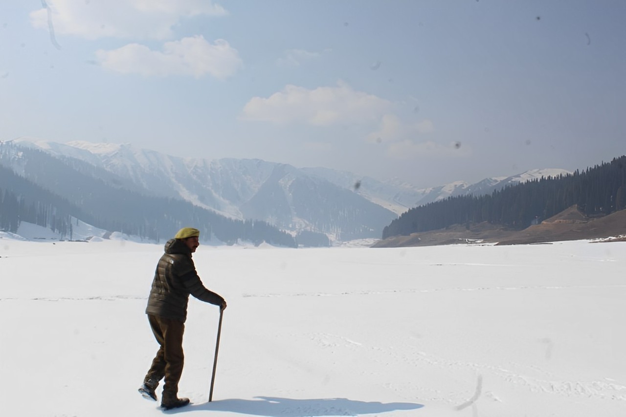 Amid the dry spell across Kashmir A policeman walks amid the snowy landscapes at Bungus valley in Kupwara district on January 21 2024