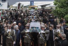 Army members carry the flag-draped coffins of President Ebrahim Raisi and his companions who were killed in a helicopter crash on Sunday in a mountainous region of the country's northwest, during a funeral ceremony at Mehrabad airport in Tehran, Iran, Tuesday, May 21, 2024. (Iranian Presidency Office via AP)