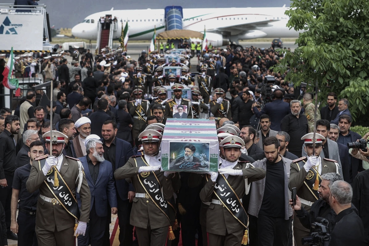 Army members carry the flag-draped coffins of President Ebrahim Raisi and his companions who were killed in a helicopter crash on Sunday in a mountainous region of the country's northwest, during a funeral ceremony at Mehrabad airport in Tehran, Iran, Tuesday, May 21, 2024. (Iranian Presidency Office via AP)