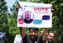 Engineer Rasheed: The Langate Simpleton Who Wishes to Move From Tihar to Parliament A man is holding a picture of Awami Ittehad Party chief Sheikh Abdul Rashid, also known as Engineer Rashid, during an election campaign in Central Kashmir's Budgam district.( Picture credit: Nissar Ahmad)