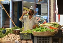 A vendor drinks water to beat the heatwave at a market in Bandipora, North Kashmir, on July 28, 2024. (KL Image: Muqeet Mubashir)