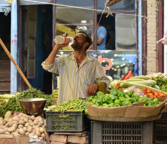 A vendor drinks water to beat the heatwave at a market in Bandipora, North Kashmir, on July 28, 2024. (KL Image: Muqeet Mubashir)