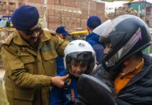 A-senior-Traffic-Police-officer-offering-a-Khyber-Cement-helmet-to-a-biker-in-Srinagar.