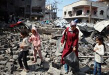 Gaza Hospitals Crumble Under Israeli Offensive, WHO Warns of Critical Collapse A-UNFPA-photograph-shows-a-fmaily-in-Gaza-looking-through-the-rubble-of-a-destroyed-building